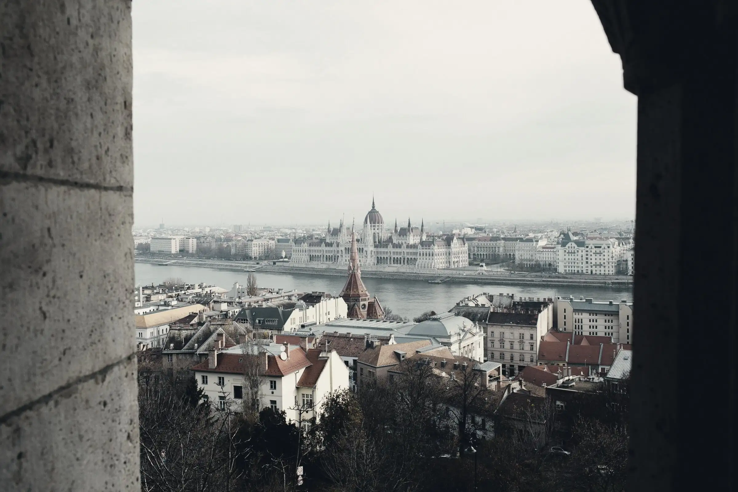Kilátás egy kőablakból Budapestre, a Duna és a Parlament épülete